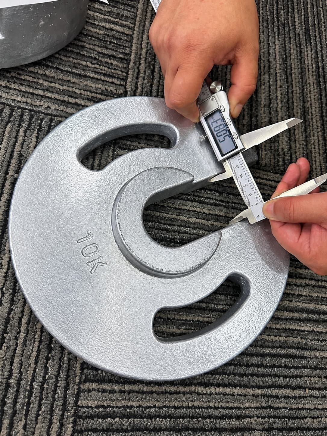 Digital caliper checking a cast iron weight opening