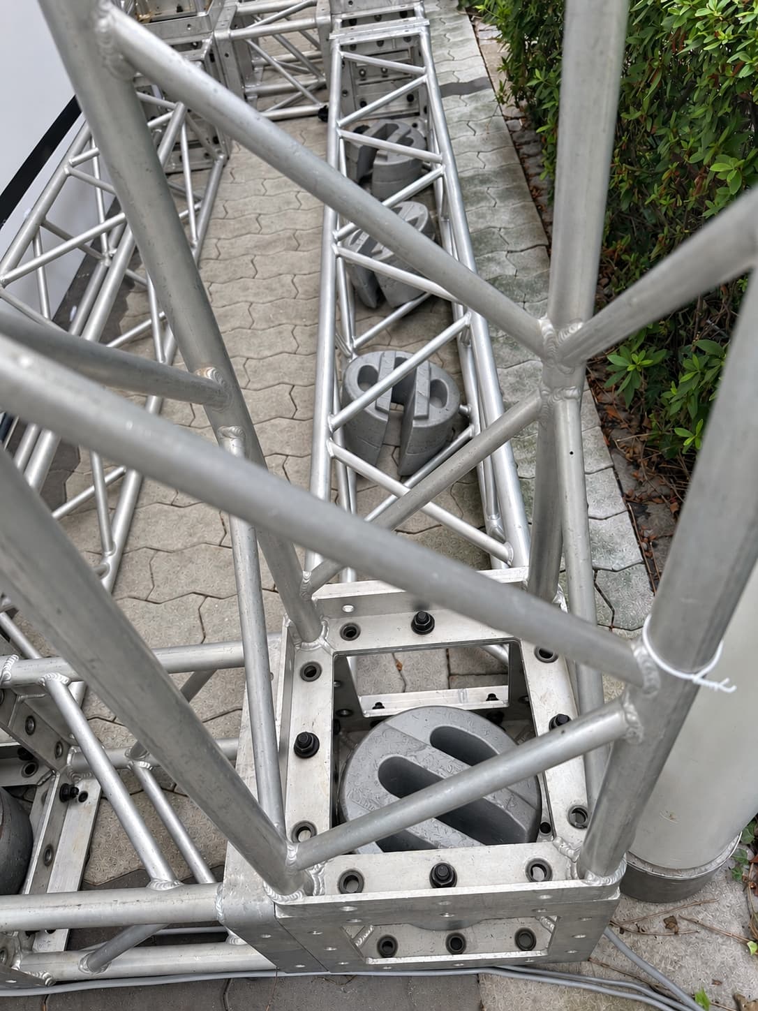 Open-slot cast iron weight positioned inside a metal truss structure