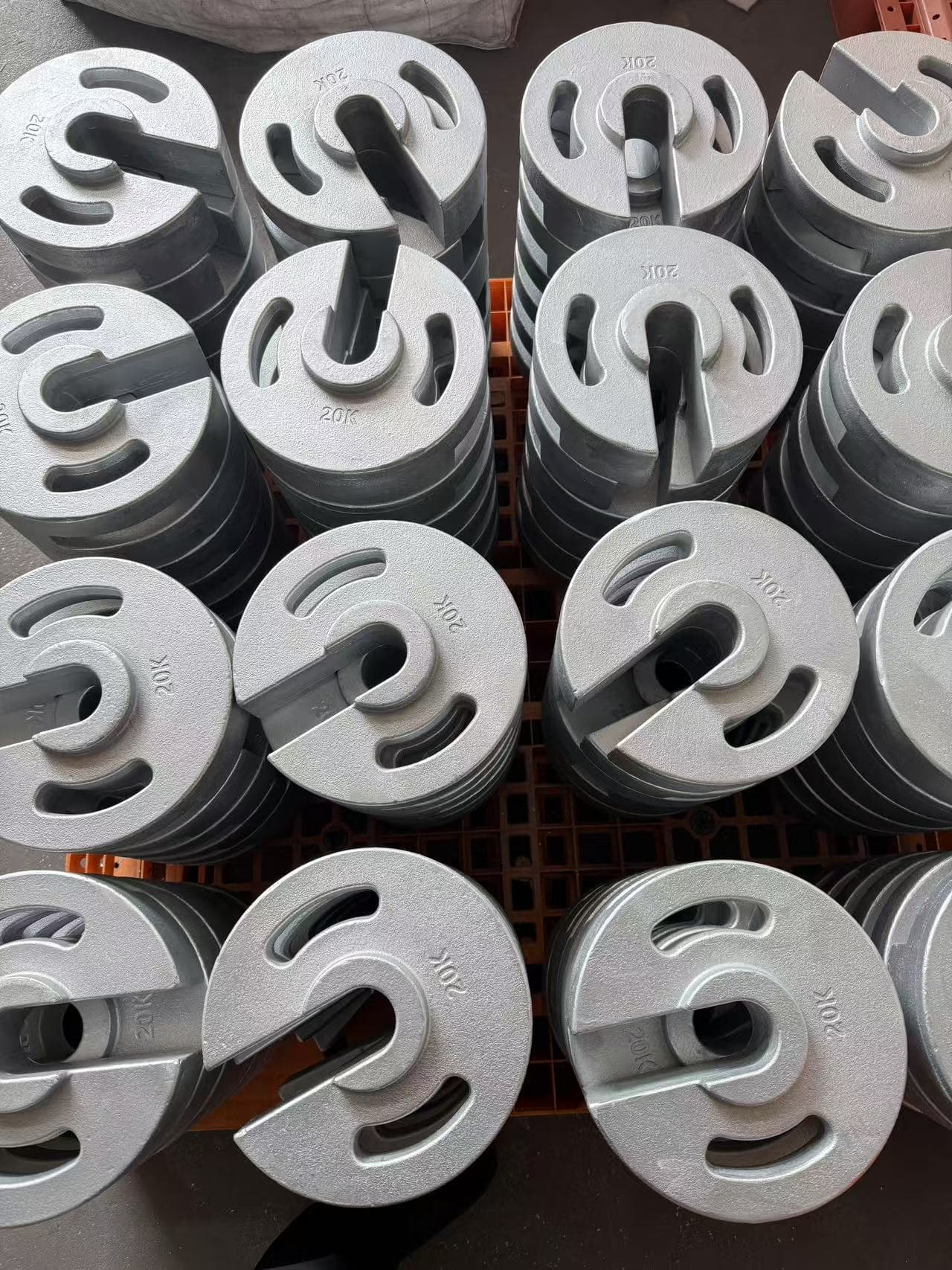 Finished cast iron tent weights arranged in batches