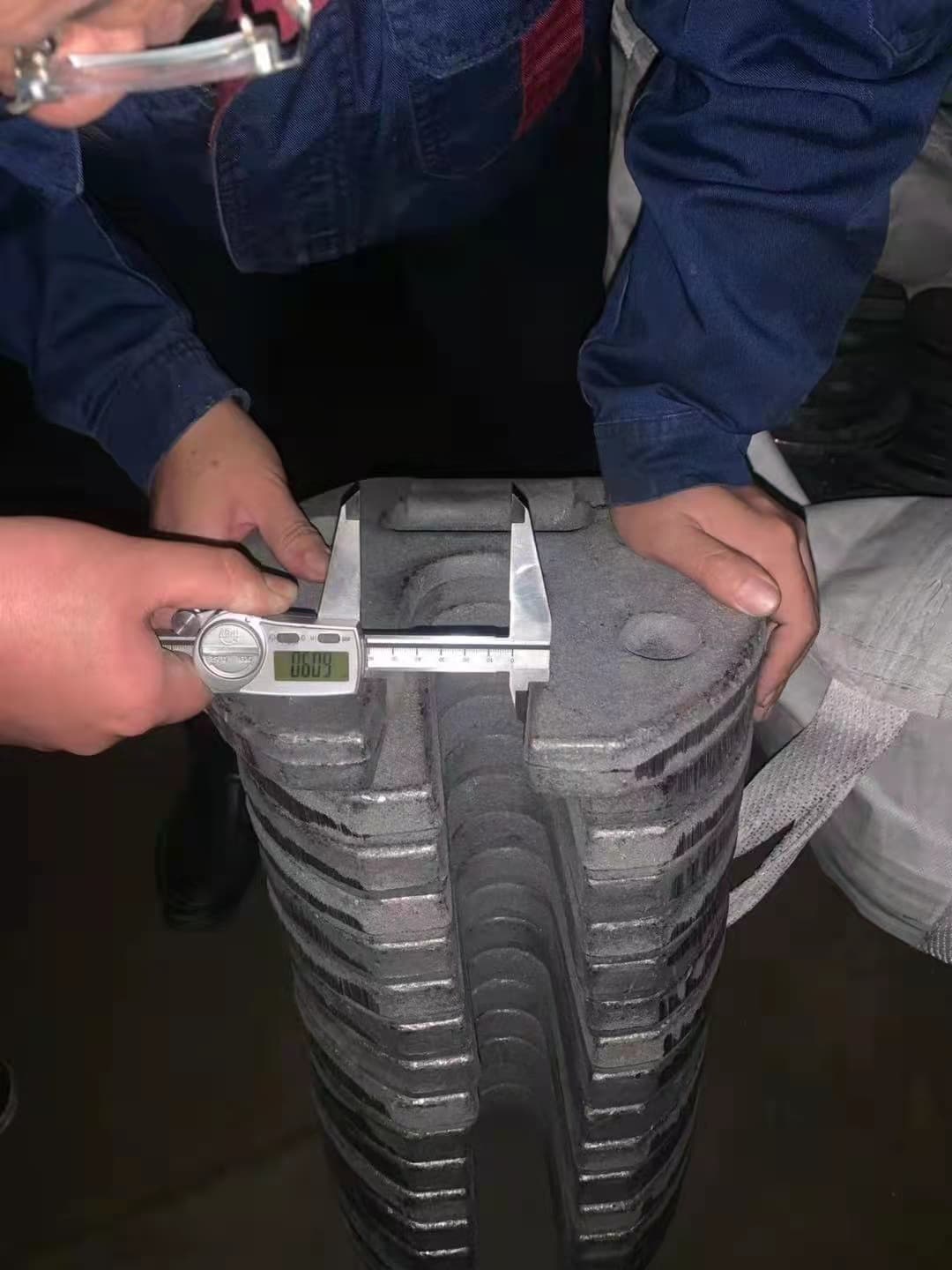 Digital caliper checking a cast iron tent weight dimension